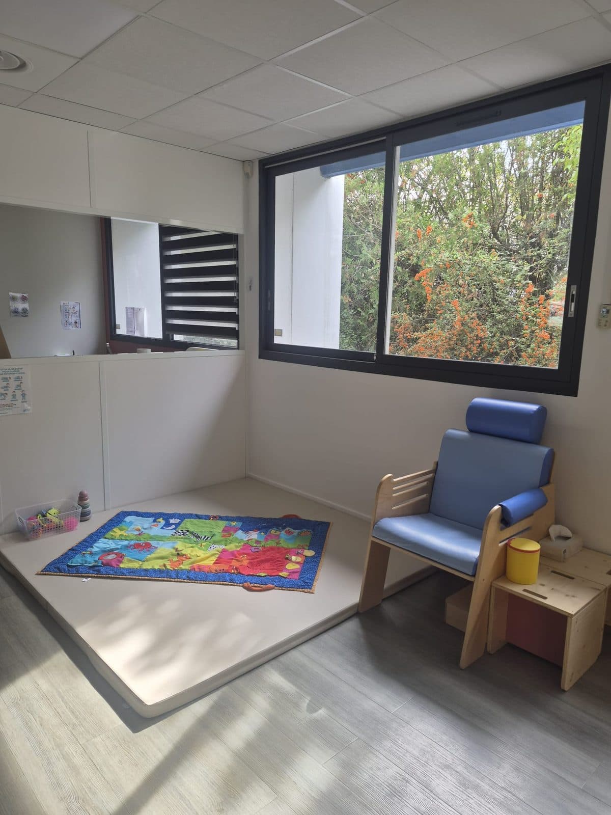 Le coin des bébés : tapis d'éveil et fauteuil à côté